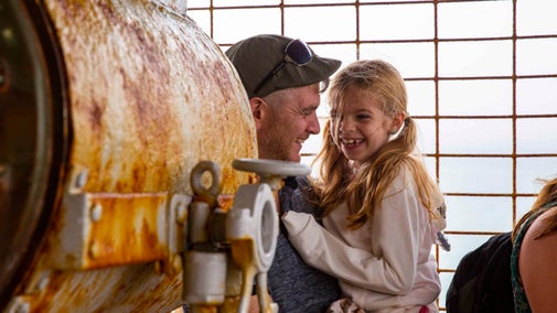 A father and child smile as they explore the buildings at Needles Old Battery and New Battery, Isle of Wight.